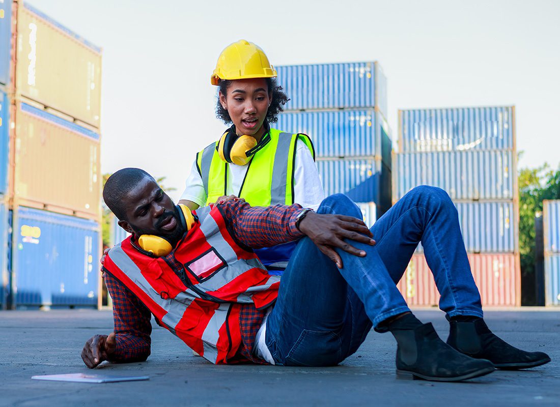 Business Insurance - Site Worker Attending to Her Injured Coworker While He is on the Ground